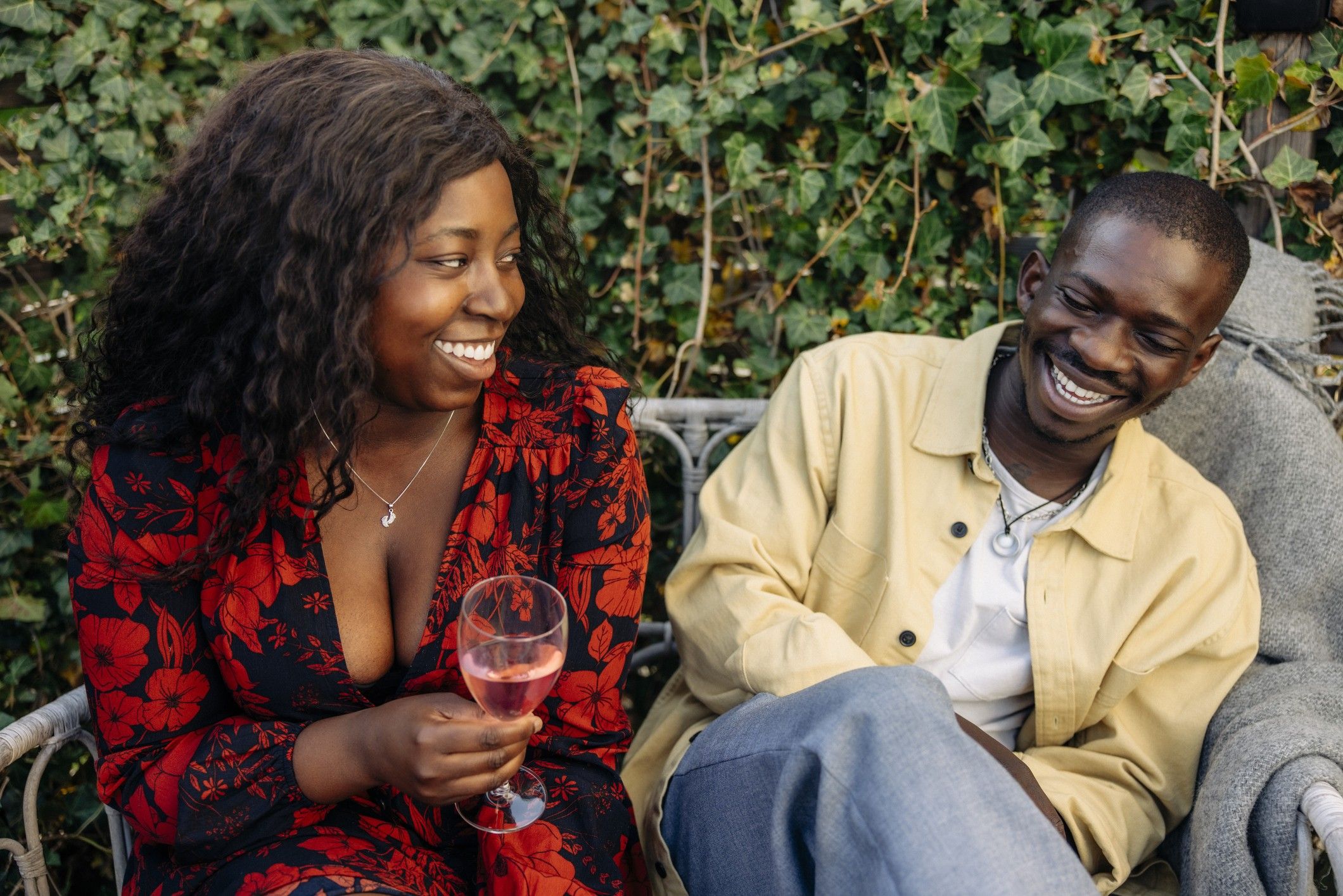 Smiling-woman-holding-drink-glass-enjoying-company-of-male-friend-at-a-party