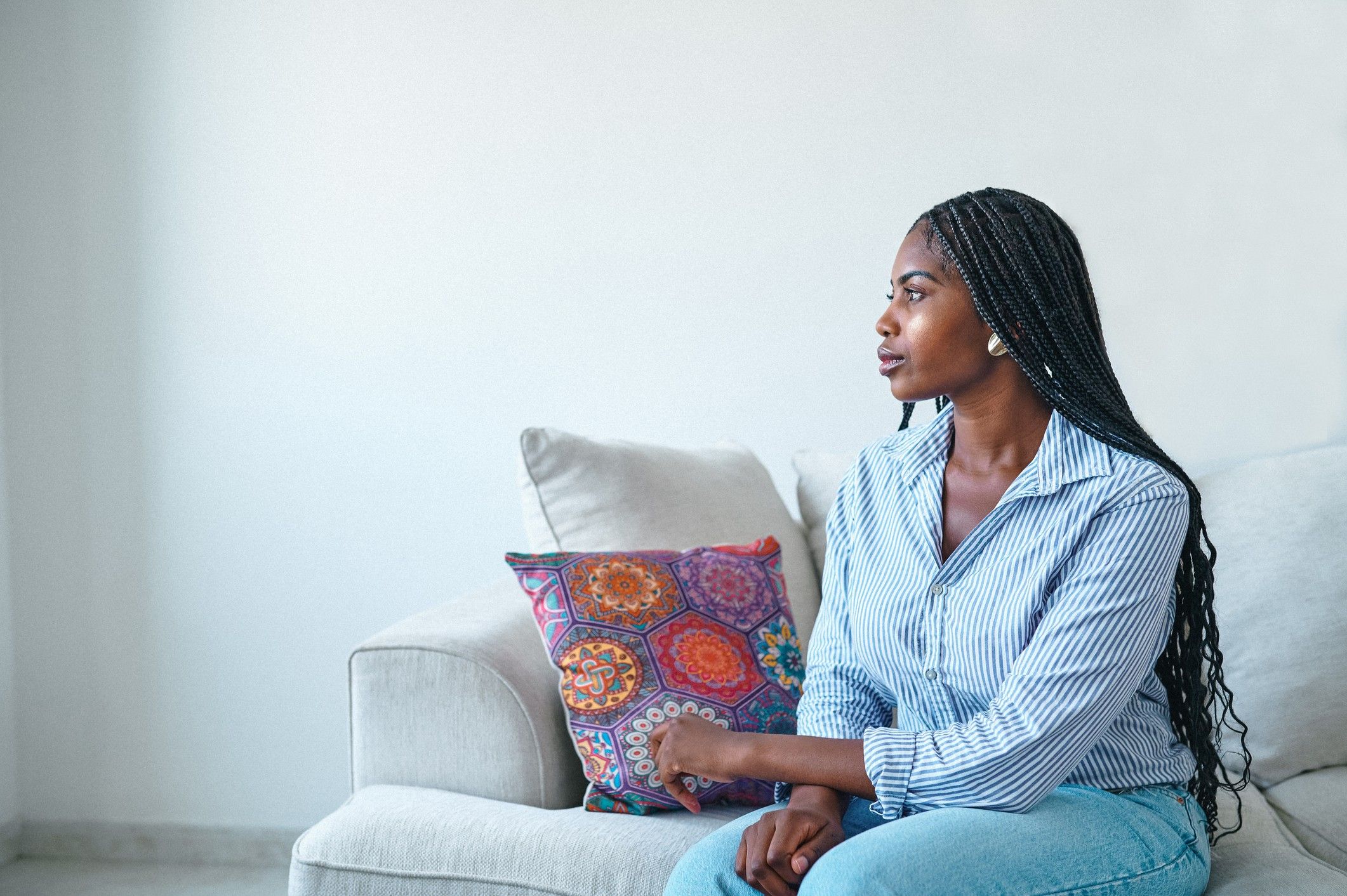 Young-woman-sitting-thinking-on-the-couch